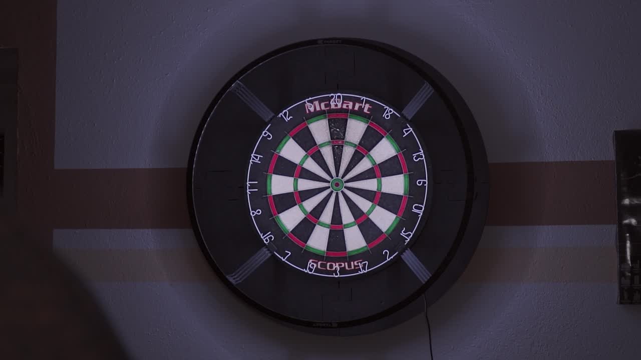 희미하게 밝은 방에서 트리플 20에 정확한 히트를 가진 다트 보드