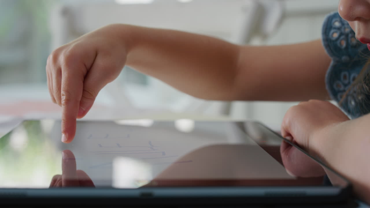 happy child using tablet computer little girl drawing pictures on touchscreen device enjoying childhood creativity playing games on mobile device at home 4k