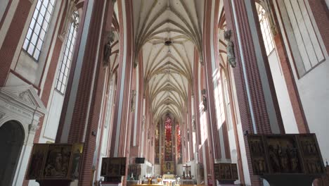 inside the church of our lady on the sand in wroclaw, poland. high vaulted ceilings, stained glass windows. tilt down view from ceiling