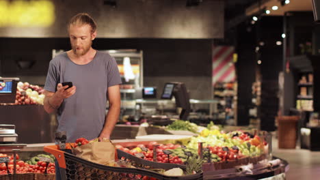 caucasian young man talking on smartphone in a supermarket