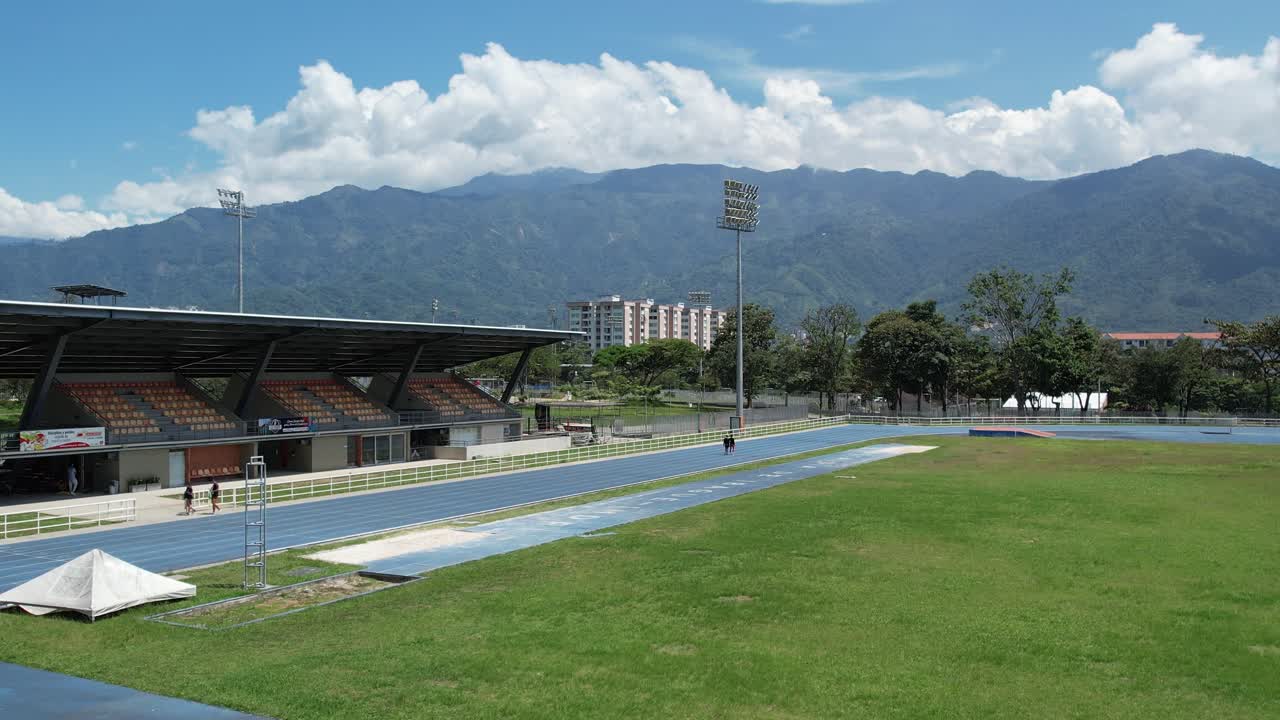 Drone video of a bright blue outdoor running track located in a public sports complex used for athletics training fitness workouts and competitive track and field events on a clear sunny day