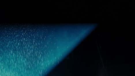 abstract dark background with blue cold flashing light beam spot and laser illuminate falling rain and smoke