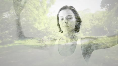 digital composition of caucasian woman meditating against view of forest path