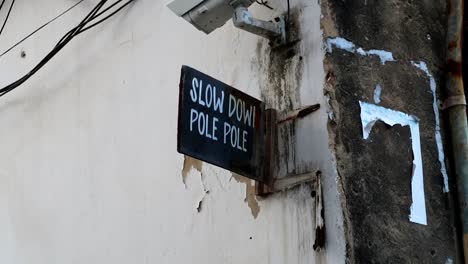 zanzibar street velocity sign saying slow down pole pole