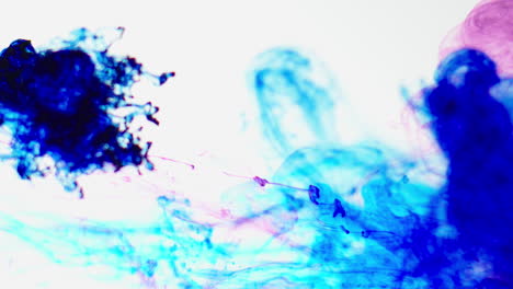 Purple-And-Blue-Paint-Or-Dye-Dropped-Into-Water-Against-White-Background-To-Create-Swirling-Colourful-Smoke-Background-1