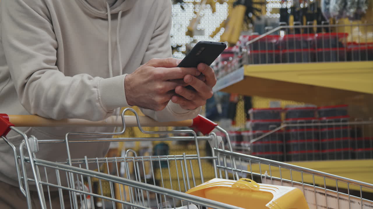 Unrecognizable Men Using Mobile Phone at Store