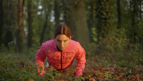 woman doing push-ups in a forest