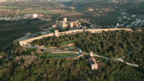 The-Walls-Of-The-Medieval-Castle-Town-Of-Obidos-In-Portugal-On-A-Sunny-Day---aerial-drone-shot