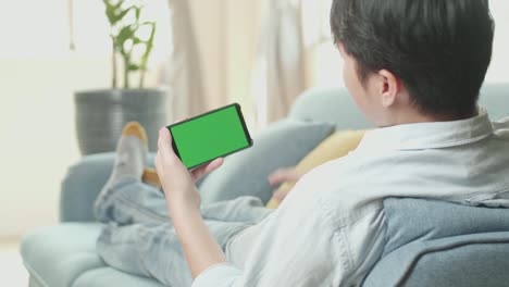 man relaxing on couch using smartphone for video call