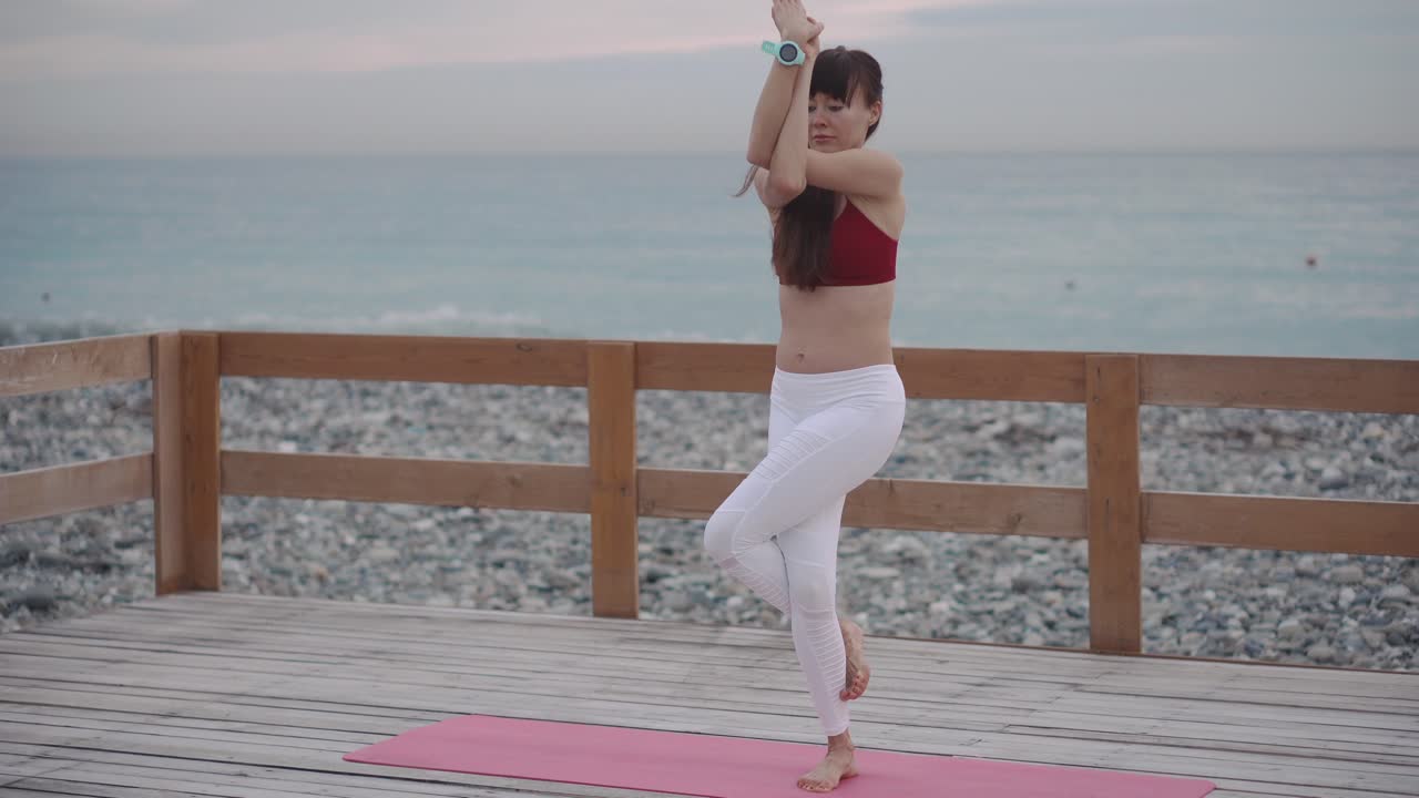 Kvinde dyrker yoga på en strandaltan