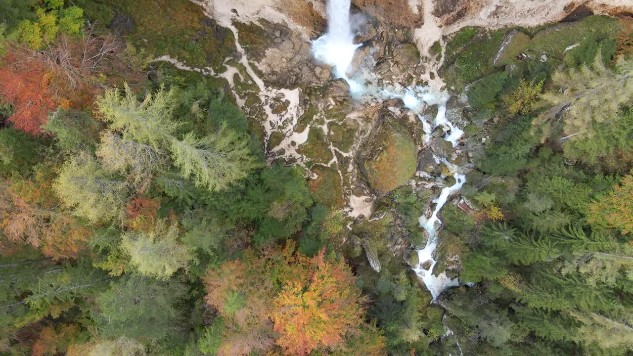 Aerial over waterfall river stream water crashing rocks falling green forest day