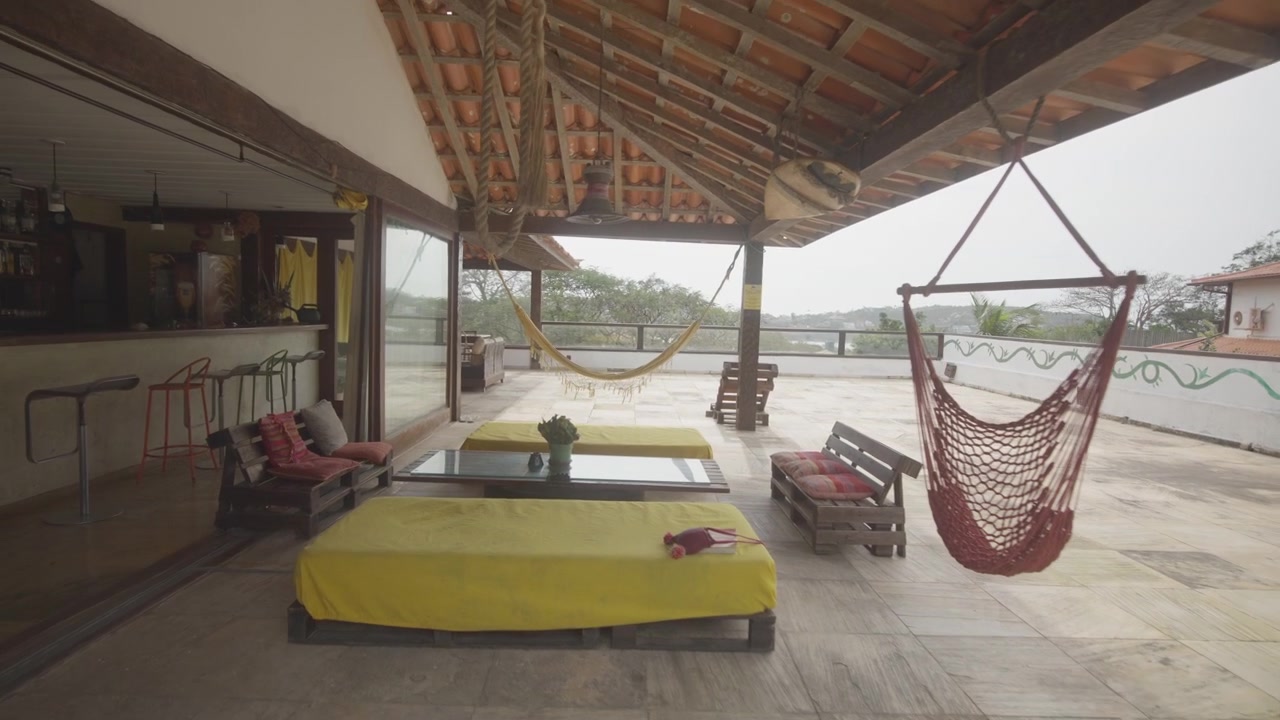 Una terrazza aperta con amache e mobili in pallet affacciata sul mare