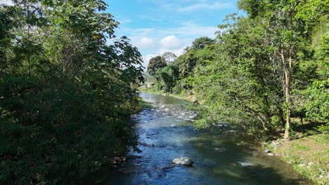 Slow-drone-flight-over-Caribbean-Rio-Yaque-del-Norte-during-sunny-day-in-Jarabacoa