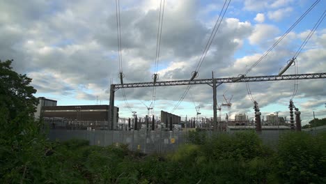 pan right on a power station with power lines and electricity cables