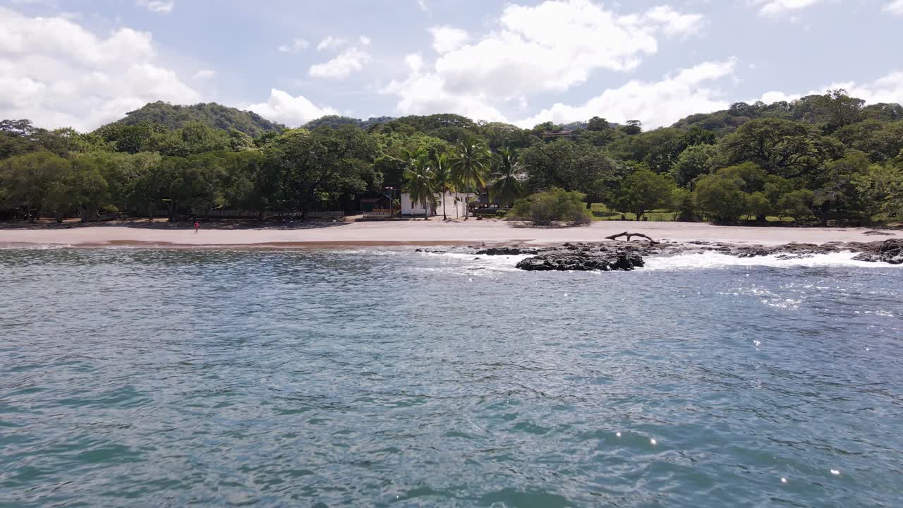 panorámica aérea lenta hacia adelante desde el mar hacia la playa en la playa real