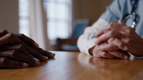 hands of a doctor and patient on a table during a medical consultation