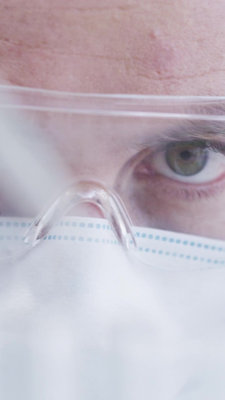 Scienziato con indumenti protettivi al lavoro in laboratorio