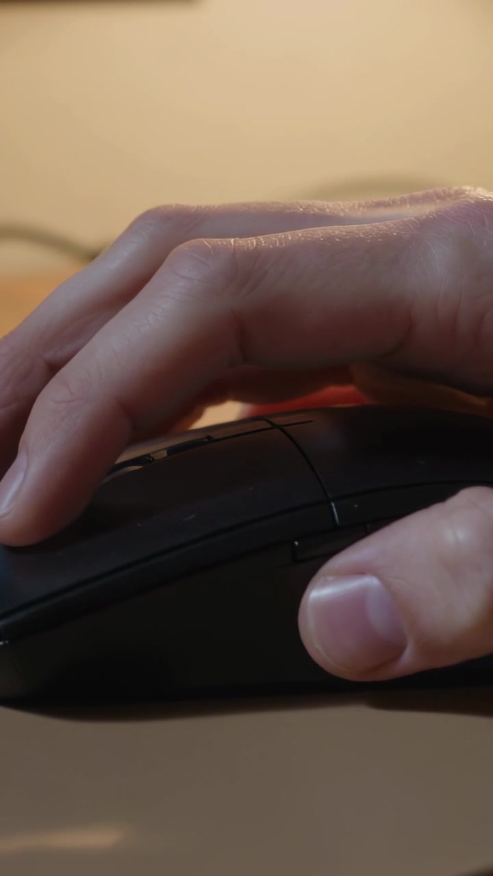 Vertical video: Index finger flexing, right hand clicking to control computer at desk, black mouse