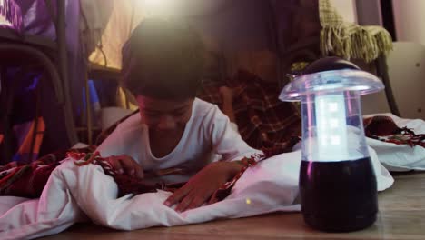 Boy-using-digital-tablet-while-relaxing-on-bed