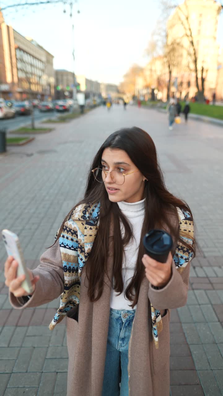 una mujer joven tomando una selfie en una calle de la ciudad