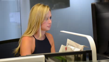 Pretty-blond-woman-working-at-desk-on-computer