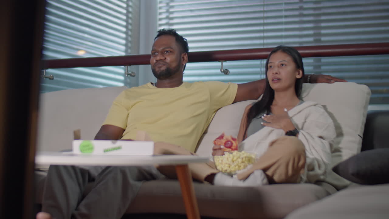Joyous Family Couple Watching TV in Evening at Home