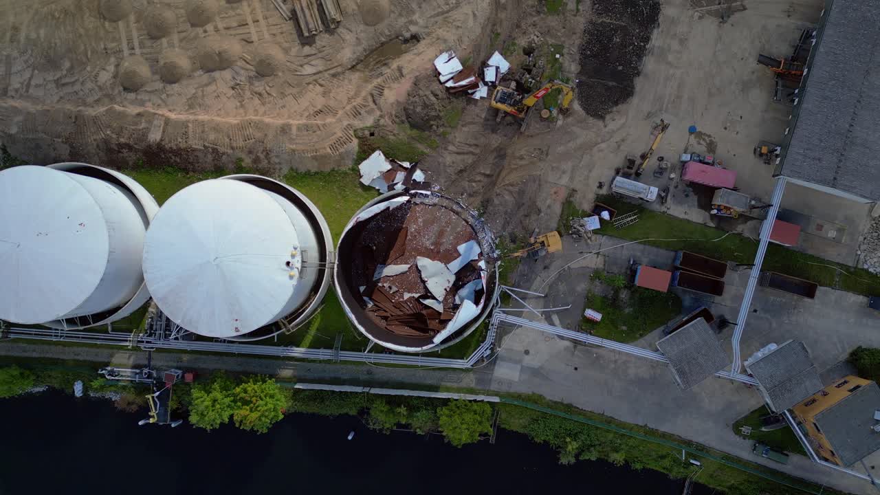bird's eye view drone of a Demolition Decommissioning Industrial storage tanks holding oil and gas products next to a busy construction area. Best aerial view flight drone camera pointing down