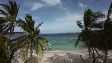 Fpv-drone-shot-a-secluded-beach-with-palm-trees-and-turquoise-seascape-in-Coron,-Philippines