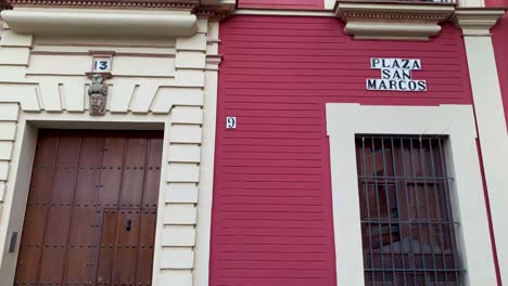 close up red facade with plaque in san marcos square seville