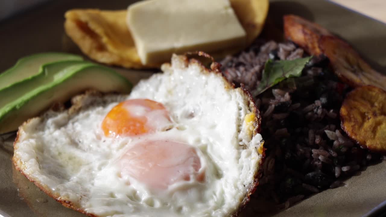 desayuno equilibrado, saludable y tradicional costarricense con huevos fritos, aguacate, arroz y frijoles, tortilla y queso