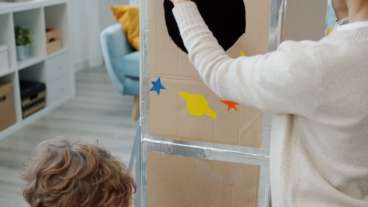 Mom and Child Building a Cardboard Rocket
