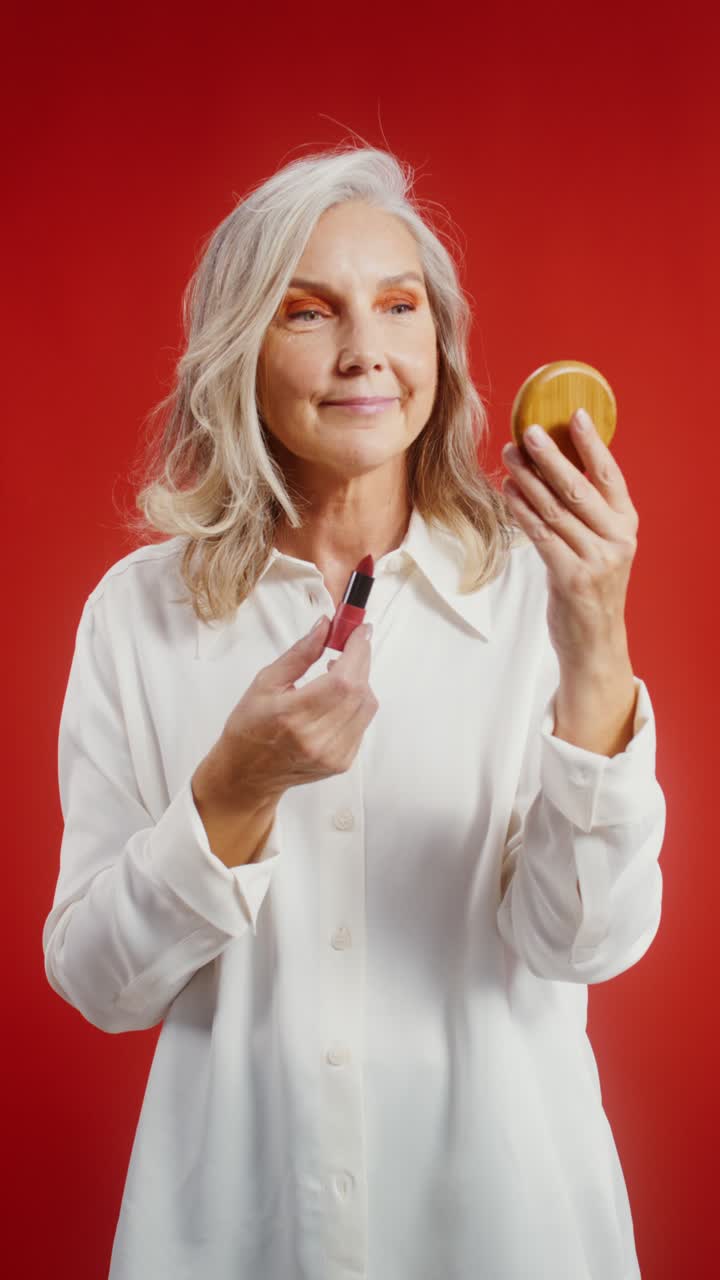 Mature Woman Applying Lipstick