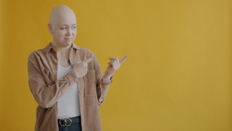 woman with a bald head pointing towards the right