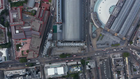 Aerial-birds-eye-overhead-top-down-view-of-traffic-in-streets.-Panning-view-of-St-Pancras-train-station-and-surrounding-buildings.-London,-UK