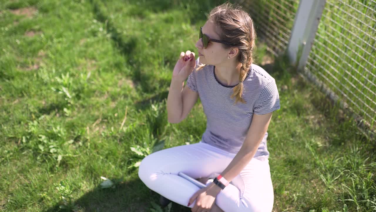 retrato de una atractiva mujer caucásica sonriente en un parque con gafas