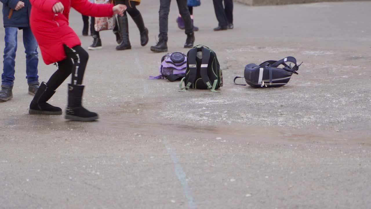 School children playing and walking outside in winter.