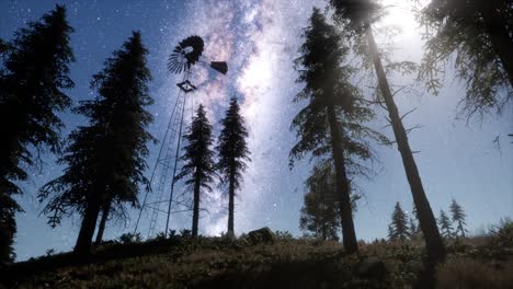 molino de viento retro en el bosque de montaña con estrellas. hiperlapso