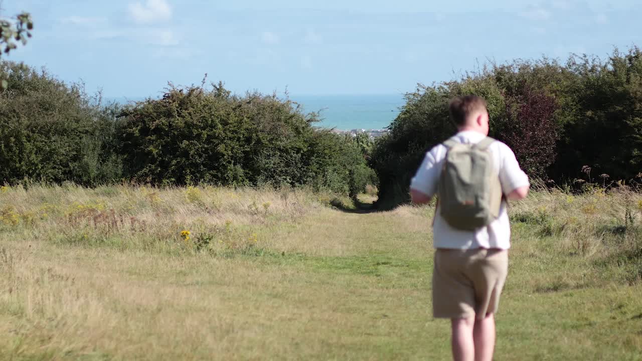한 남자가 잔디로 인 언덕 길을 고 있다
