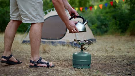 hombre cocinando al aire libre con una estufa portátil