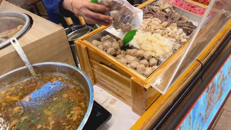 preparing thai meatballs soup at a street food stall