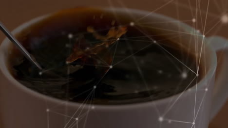 dark coffee being stirred in ceramic cup by spoon, with glowing nodes and lines overlaying scene
