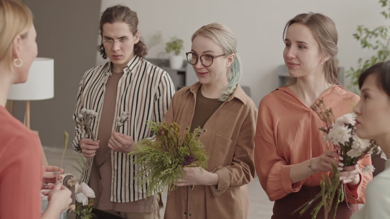 Busy Cheerful Florists Communicating in Shop