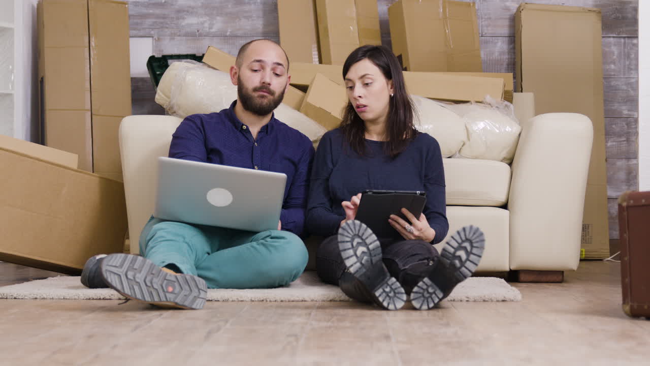 Couple planning move with laptop and tablet