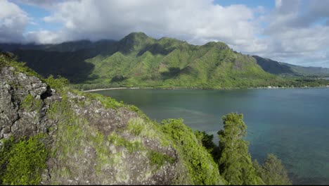 aerial reveal bird's eye view of crouching lion hike overlooking kahana valley and bay, hawaii