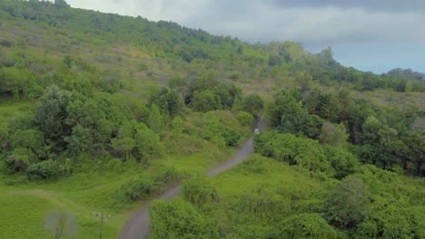 Vista-Aérea-De-La-Isla-Hawaiana-Maui-Y-Su-Paisaje-Verde-Montañoso-Y-Carretera