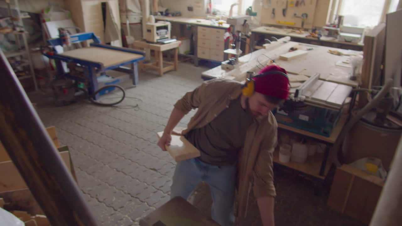 Carpenter Working on Wooden Plank in Workshop