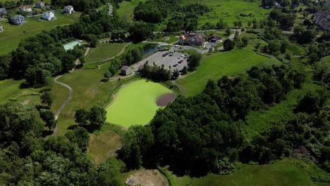 Vista-Aérea-De-Una-Casa-De-Banquetes-Para-Celebraciones-Y-Bodas,-Rodeada-De-árboles-Y-Tierras-Verdes