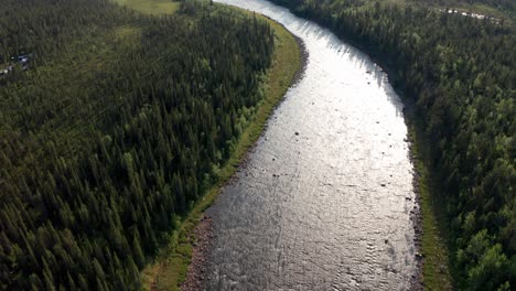 drone shot of wild river in northern sweden surrounded by deep forest