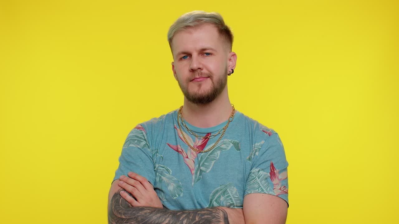 미소 짓는 장난스러운 행복한 남자가 눈을  ⁇ 이고, 이빨이 있는 미소로 카메라를 쳐다보고, 눈을  ⁇ 고 유혹합니다.