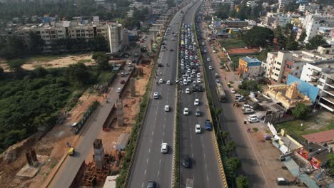 indian highway bridge on cinematic aerial footage with heavy traffic due to accident and the construction of a metro train bridge construction above the service road